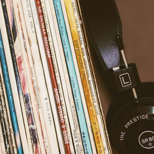 Black headphones resting against a row of vintage vinyl record albums, illustrating Amazon's cloud music service