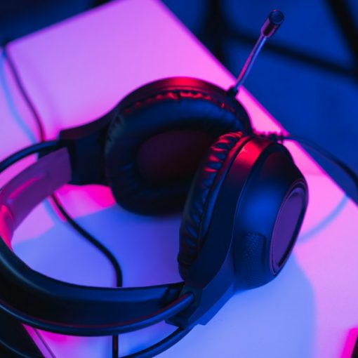 Black and red corded headphones on white table, illustrating cloud-based music streaming
