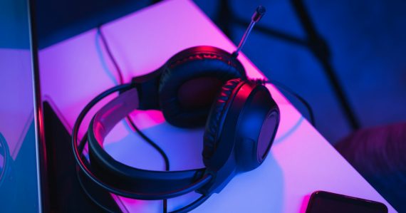 Black and red corded headphones on white table, illustrating cloud-based music streaming