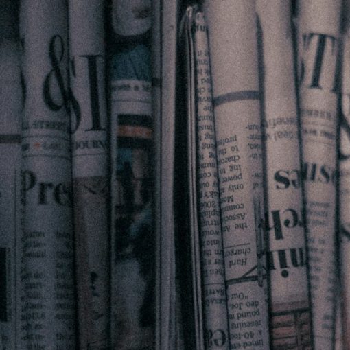 A row of newspapers sitting on top of a shelf, illustrating cloud computing as newsmaker of the year