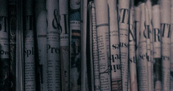 A row of newspapers sitting on top of a shelf, illustrating cloud computing as newsmaker of the year
