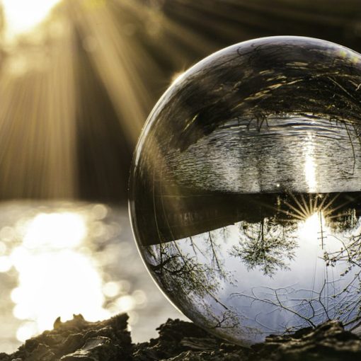 Clear glass ball resting on autumn leaves, illustrating cloud computing predictions for 2015