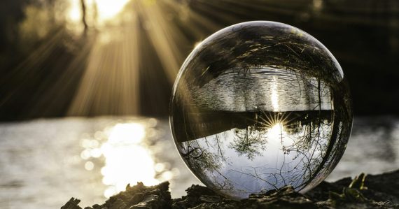 Clear glass ball resting on autumn leaves, illustrating cloud computing predictions for 2015