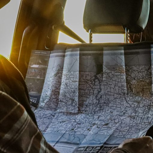 Man studying a map in a car at sunset, illustrating creating a cloud roadmap