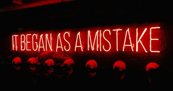 A neon sign that says it began as a mistake, illustrating common cloud security mistakes