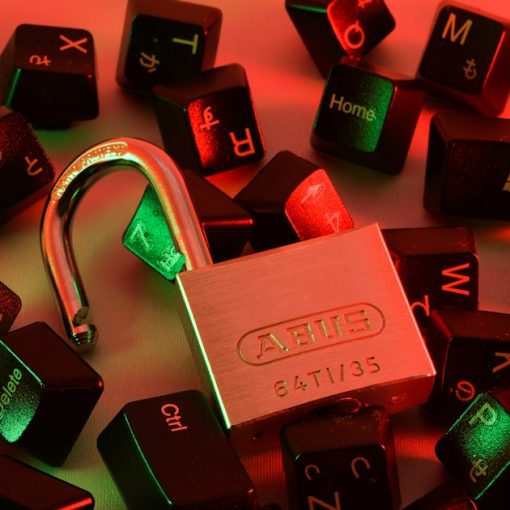 An open padlock surrounded by scattered black computer keyboard keys, illustrating essential cloud security tips