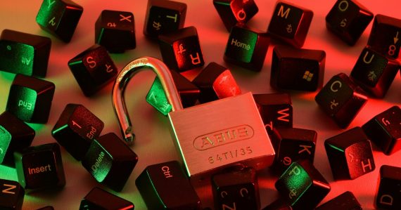 An open padlock surrounded by scattered black computer keyboard keys, illustrating essential cloud security tips
