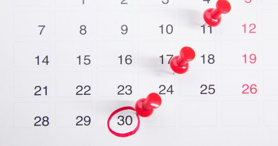A calendar with red push buttons pinned to it, illustrating small businesses planning cloud adoption