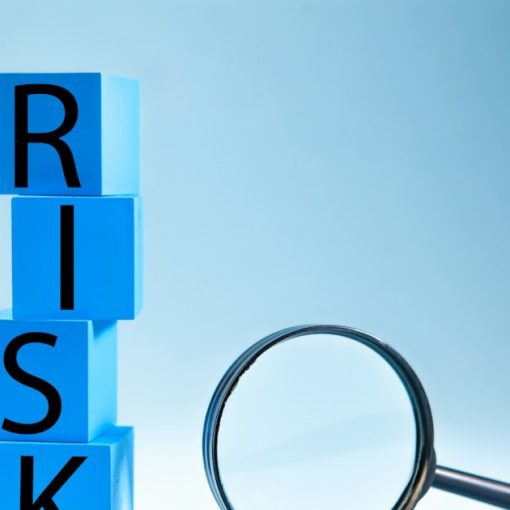 Blocks spelling risk next to a magnifying glass, illustrating shadow IT financial risk