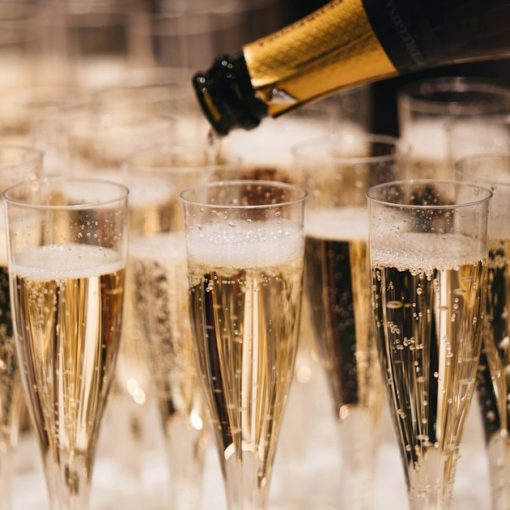 Champagne pouring from a bottle into a group of flutes on a tray, illustrating funding for cloud computing startups