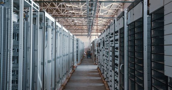 Server room aisle lined with metal equipment racks, illustrating the cloud storage battle