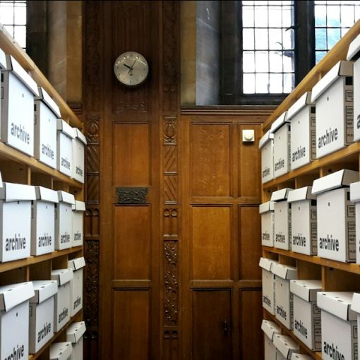 Rows of white archive boxes on wooden shelves, illustrating how businesses use cloud storage