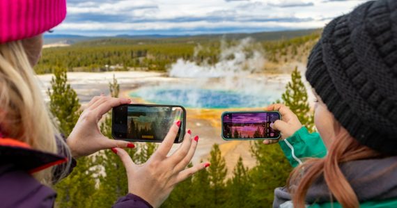 Two people taking photos of a hot spring, illustrating the Color mobile social network