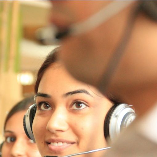 Two women wearing headsets in a bright office, illustrating cloud computing in the contact center