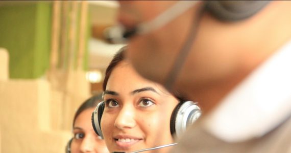Two women wearing headsets in a bright office, illustrating cloud computing in the contact center
