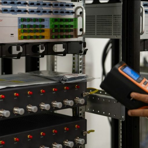 Technician inspecting server racks with a handheld diagnostic tool, illustrating a cloud computing data center