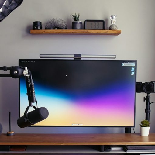 A desk with a monitor, keyboard and headphones, illustrating desktop virtualization explained