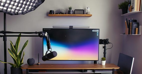 A desk with a monitor, keyboard and headphones, illustrating desktop virtualization explained