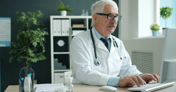 Doctor typing on computer in office, illustrating healthcare leading desktop virtualization adoption