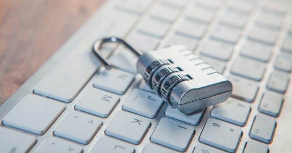 A combination lock rests on a computer keyboard, illustrating desktop virtualization improving security