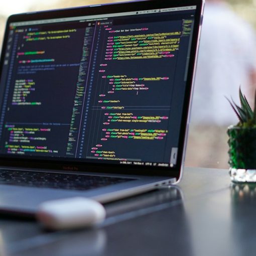 Laptop showing programming code on a café table, illustrating DevOps in the cloud