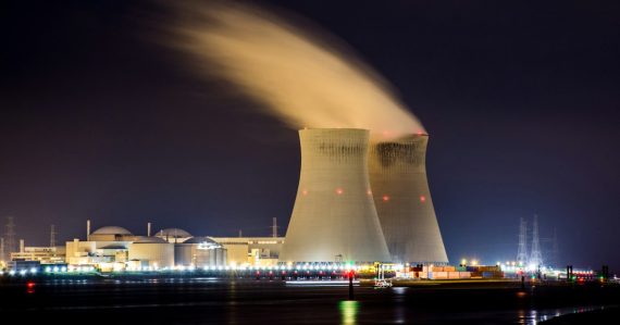 Power plant cooling towers emitting steam at night, illustrating embedded virtualization securing industrial networks