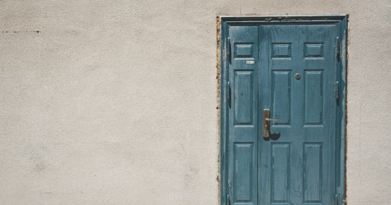 Closed door and white painted wall, illustrating entering the cloud
