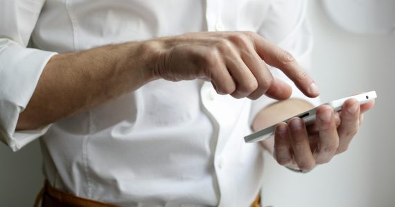 Person holding white Android smartphone, illustrating linking personal mobile devices to enterprises