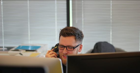 Man using IP phone inside room, illustrating enterprise VoIP decisions