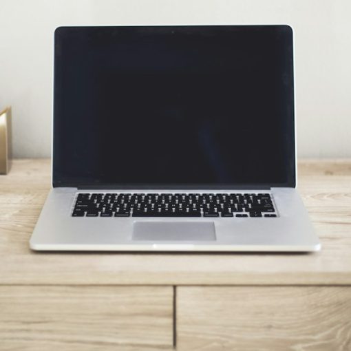 MacBook Pro on top of brown table, illustrating essentials of cloud computing
