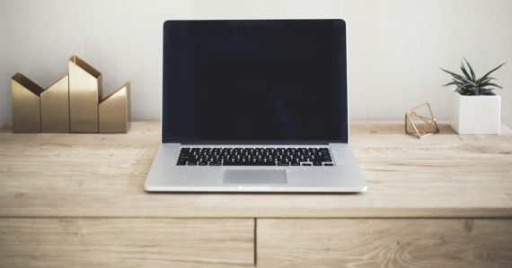 MacBook Pro on top of brown table, illustrating essentials of cloud computing