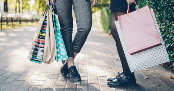 Two women with shopping bags on a sidewalk, illustrating evaluating cloud computing providers