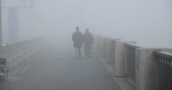 Two people walking on a bridge in the fog, illustrating the evolving role of the CIO in the cloud