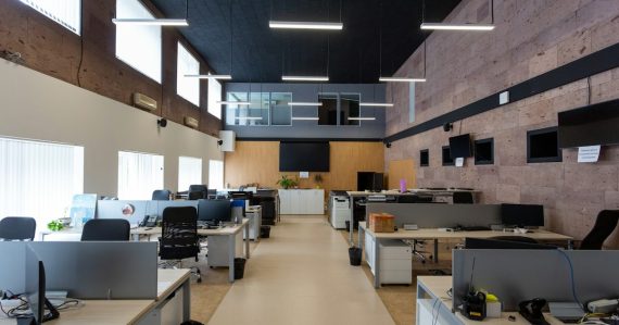 An open plan office with rows of desks and computers, illustrating government cuts driving cloud and outsourcing