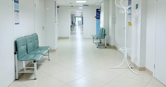 Empty hospital corridor with benches and doors, illustrating healthcare slow to adopt the cloud