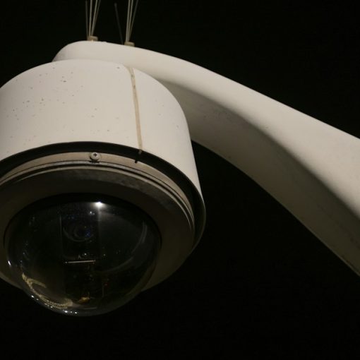 A close up of a security camera on a pole, illustrating detecting intruders in cloud systems