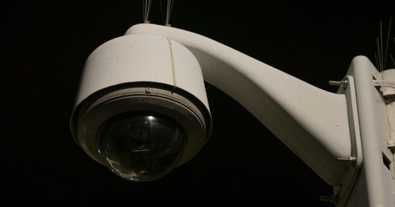 A close up of a security camera on a pole, illustrating detecting intruders in cloud systems