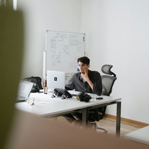 Man in black suit sitting on black office rolling chair, illustrating hosted voice services