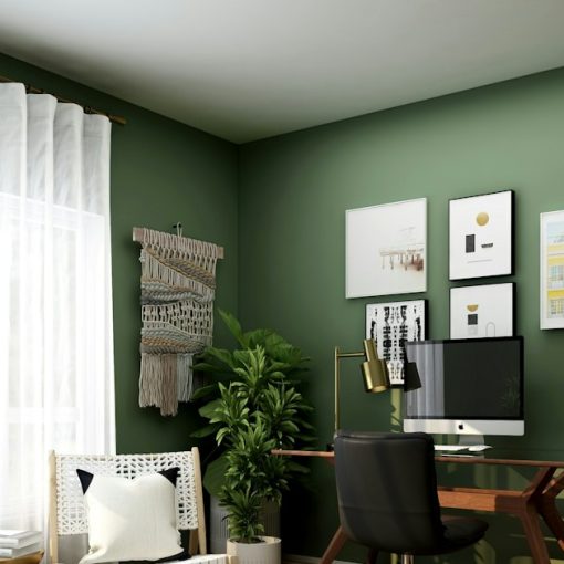 A home office with a wooden desk, black chair, and green walls, illustrating hosted VoIP trends for SMBs