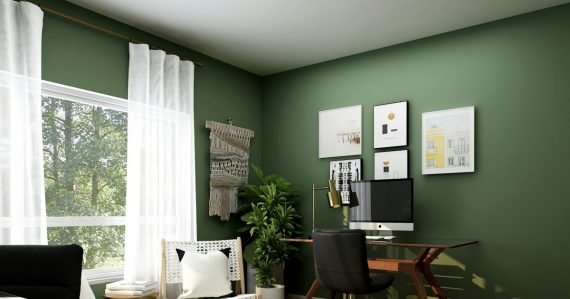 A home office with a wooden desk, black chair, and green walls, illustrating hosted VoIP trends for SMBs