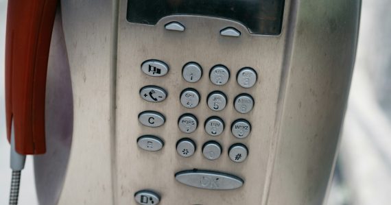 A close up of a phone with a red cord, illustrating reasons to choose hosted VoIP