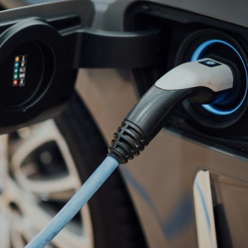 Electric vehicle charging cable plugged into car, illustrating hybrid cloud computing explained