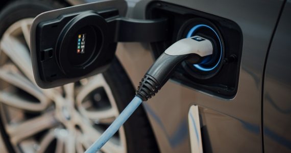 Electric vehicle charging cable plugged into car, illustrating hybrid cloud computing explained
