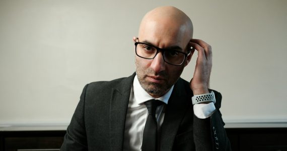 A man in a suit and tie sitting at a table, illustrating real versus imagined cloud worries