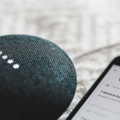Charcoal Google Home Mini and smartphone, illustrating the Internet of Things and the future CIO