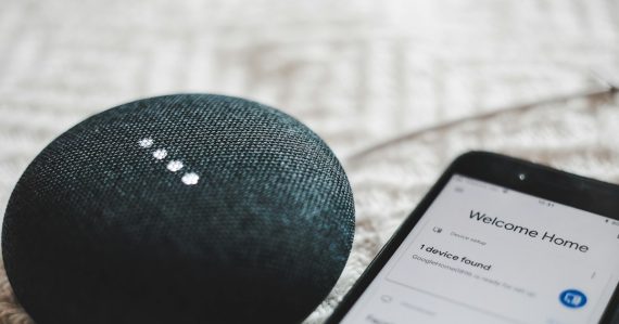 Charcoal Google Home Mini and smartphone, illustrating the Internet of Things and the future CIO