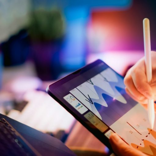 Person using stylus on tablet with charts, illustrating the iPad's role in desktop virtualization