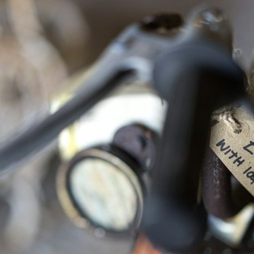 A vintage motorcycle handlebar with a handwritten price tag attached, illustrating understanding the cost of IT services