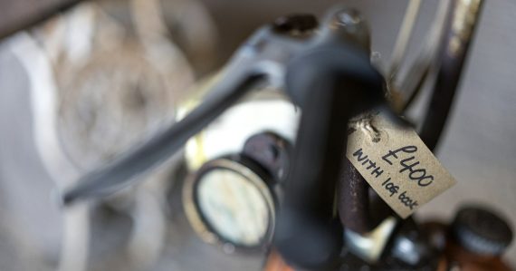 A vintage motorcycle handlebar with a handwritten price tag attached, illustrating understanding the cost of IT services