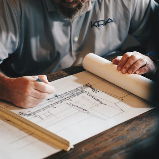 Architect drafting plans with a pencil and ruler, illustrating key questions for cloud planning